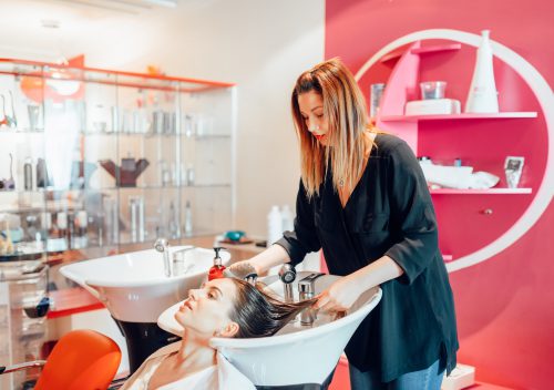 Hairdresser washes hair in hairdressing salon