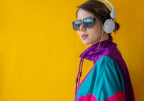 Young woman in 90s style clothes with headphones