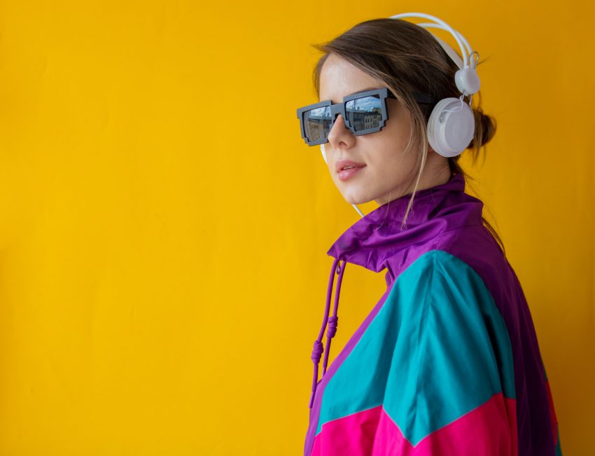 Young woman in 90s style clothes with headphones